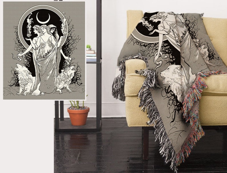 May include: A woven tapestry throw blanket features a black and white illustration of three women standing in a forest with wolves. The women are wearing long flowing robes and have long hair. The background is a dark forest with trees and branches. The blanket has a fringe border.