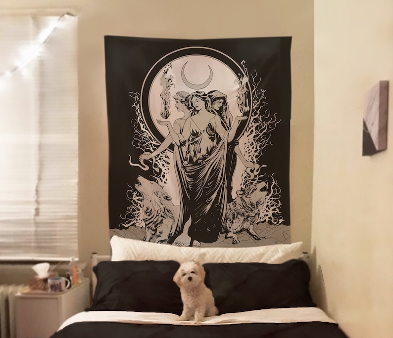 May include: Black and white tapestry featuring a triple goddess figure with a crescent moon above her head. Two wolves are flanking the goddess, and the background is a dark forest with a swirling pattern.