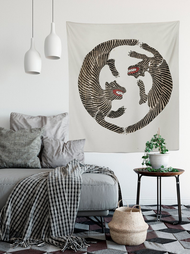 May include: A tapestry featuring a black and white illustration of two stylized wolves facing each other in a circular design. The wolves have red mouths and are set against a cream background.