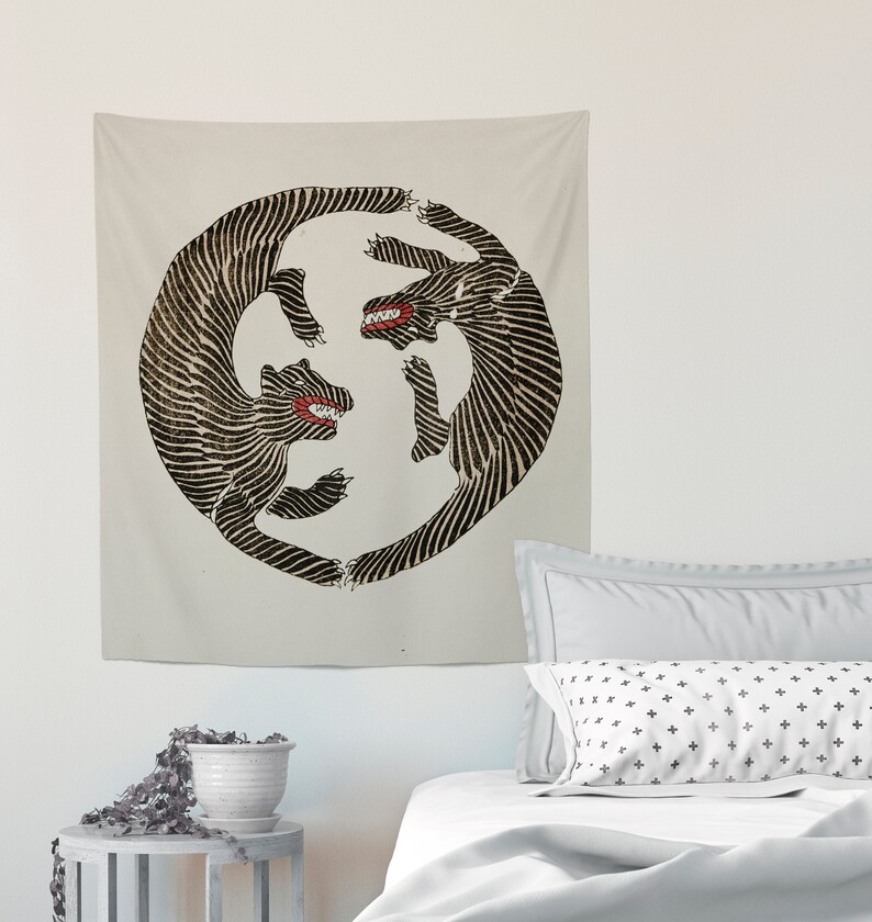May include: A tapestry featuring a black and white circular design of two stylized animals facing each other with their mouths open. The animals are outlined in black and have a striped pattern.