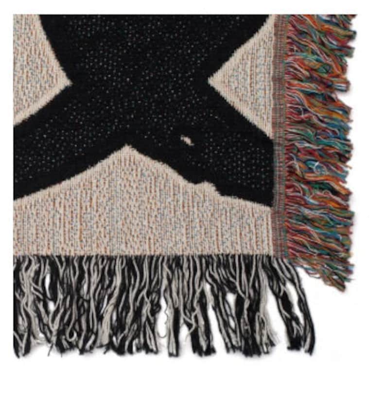 May include: Black and white woven throw blanket with a geometric pattern and fringe on the edges.