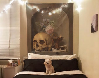 Könnte beinhalten: Ein schwarzes Bett mit weißen Bettwäsche und einem kleinen weißen Hund, der auf dem Bett sitzt. Über dem Bett hängt eine Wandteppich mit einem Schädel, Blumen und einem Kerzenhalter. Lichterketten sind an der Wand befestigt.