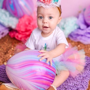 Little girl celebrating her birthday holding an 11" latex balloon with purple and pink marble design.