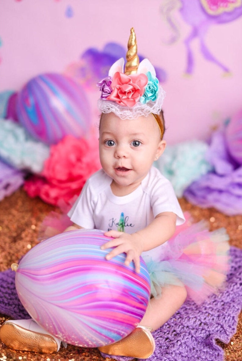 Little girl celebrating her birthday holding an 11" latex balloon with purple and pink marble design.