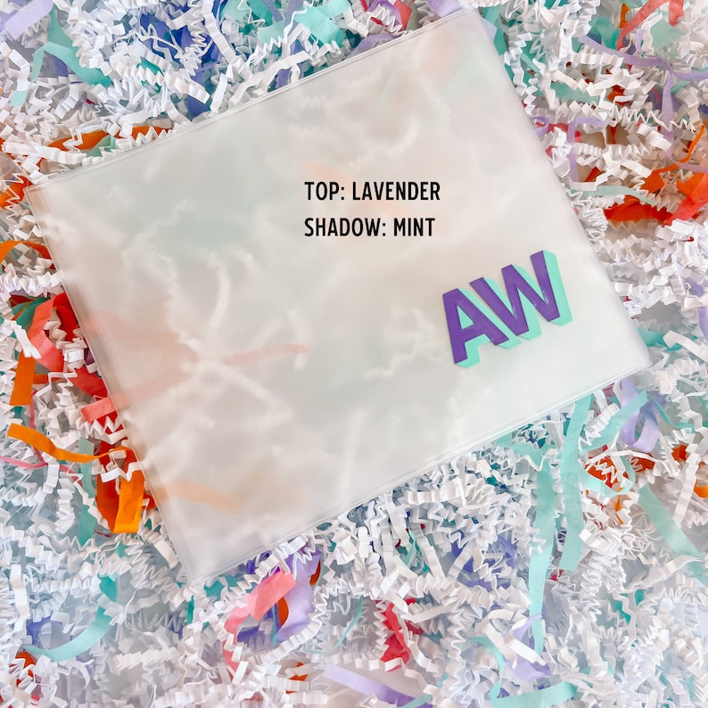 May include: A clear plastic bag with the text "TOP: LAVENDER SHADOW: MINT" and the letters "AW" in purple and turquoise.