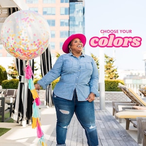 Puede incluir: Una mujer con un sombrero rosa y una camisa vaquera azul sostiene un gran globo transparente con confeti de colores en su interior. El globo est&aacute; sujeto a una larga cuerda de borlas de colores. El texto "CHOOSE YOUR COLORS" est&aacute; en letras rosas sobre un fondo blanco.