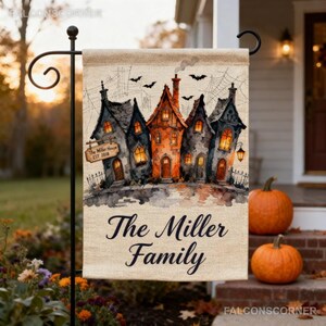 May include: A rectangular garden flag featuring a watercolour illustration of a spooky house with orange glowing windows, flying bats, and spiderwebs. A wooden sign hanging on the house reads The Miller House EST 2018. The text The Miller Family is printed below.