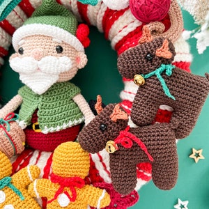 May include: A crocheted Christmas wreath with a Santa Claus, two reindeer, and two gingerbread people. The wreath is decorated with red and white candy canes.