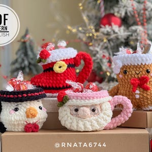 Peut inclure: Quatre tasses de Noël crochetées, dont un bonhomme de neige, le Père Noël, un bonhomme en pain d'épices et une botte du Père Noël. Chaque tasse est remplie de bonbons et possède une anse unique.