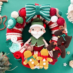 May include: A crocheted Christmas wreath with a green and white bow, a Santa Claus figure, gingerbread people, and reindeer ornaments.