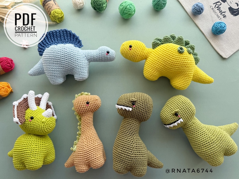 May include: A collection of handmade crochet dinosaur toys in various colors, including blue, yellow, green, and brown. The dinosaurs have different designs, such as a Triceratops and a Stegosaurus. The image also includes balls of yarn and the text "PDF CROCHET PATTERN".