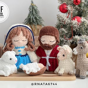 May include: A crocheted nativity scene with figures of Mary, Joseph, baby Jesus, a lamb, and a donkey. The soft yarn figures are in various colours, with a Christmas tree in the background. The image includes the text "PDF PATTERN ENGLISH".