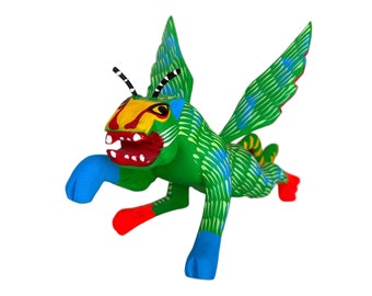 Könnte beinhalten: Eine grüne, blaue, rote und gelbe Holzskulptur eines geflügelten Wesens mit einem breiten Grinsen.