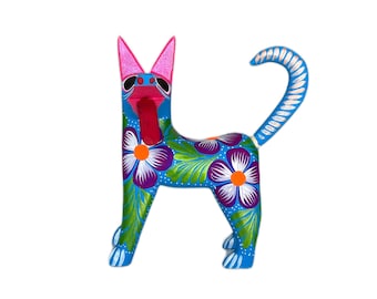 Puede incluir: Una figurita de perro de cerámica azul con orejas rosas y una lengua rosa que sobresale. El perro está decorado con flores coloridas y hojas verdes.