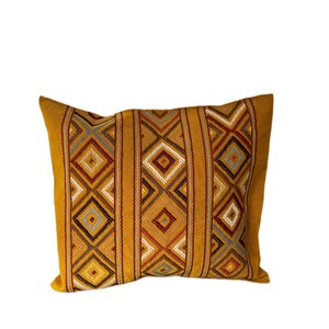 May include: A mustard yellow throw pillow with a geometric pattern in shades of brown, red, and gray.