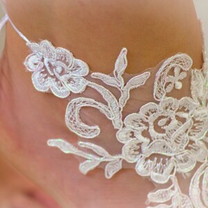 May include: White lace trim with a floral design. The lace is delicate and intricate, with a soft, feminine feel.