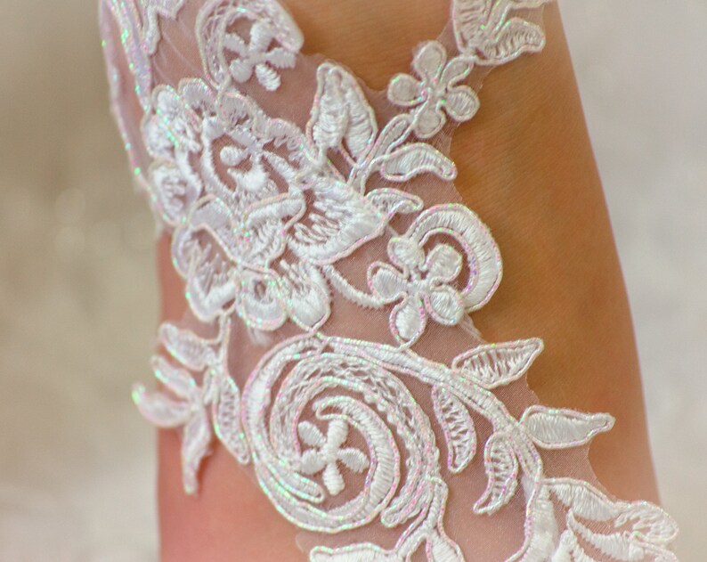 May include: White lace fabric with a floral pattern. The lace has a delicate, iridescent sheen.
