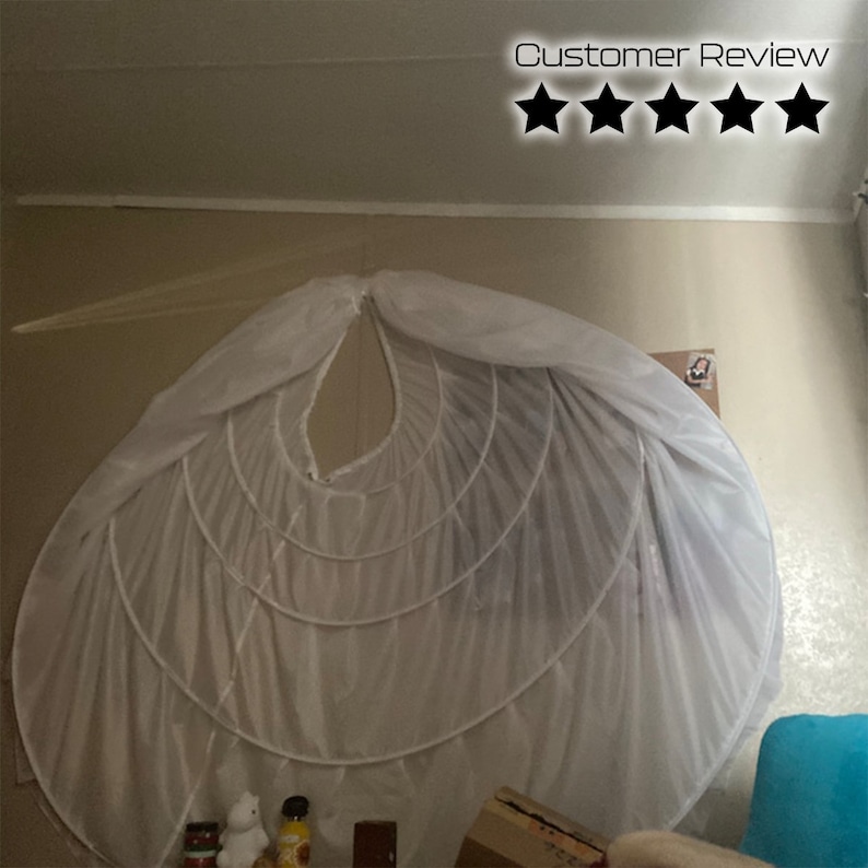 May include: A white tulle petticoat with multiple layers and a circular shape. The petticoat is hanging on a wall and is being used as a decoration.