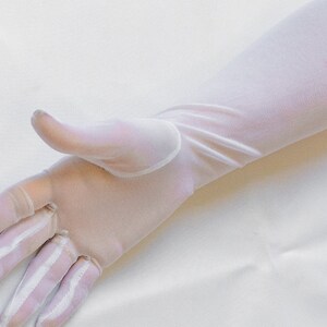 May include: A pair of long white sheer gloves. The gloves are made of a delicate, lightweight fabric and have a smooth, silky texture.