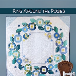 May include: A quilt pattern called "Ring Around the Posies" by Robin Pickens Quilt Patterns. The quilt features a blue and green floral design on a white background. The pattern is jelly roll friendly.