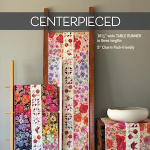 May include: Floral table runners in various lengths, displayed on wooden racks. The runners feature vibrant patterns with red poppies, blue flowers, and geometric designs. The text reads "CENTERPIECED" and "16 1/2" wide TABLE RUNNER in three lengths".