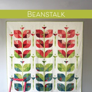 Pode incluir: Um padrão de colcha chamado "Beanstalk" com um design moderno de flores estilizadas em tons de vermelho, verde e azul. O padrão é compatível com quartos de tecido e está disponível nos tamanhos de colo, quadrado grande, duplo e queen.