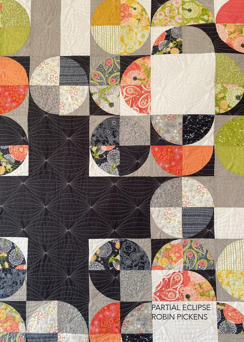 Peut inclure: Une courtepointe color&eacute;e avec un motif g&eacute;om&eacute;trique compos&eacute; de demi-cercles et de carr&eacute;s. La courtepointe comprend divers motifs et couleurs, notamment des imprim&eacute;s floraux, du gris, de l'orange et du noir. Le texte "PARTIAL ECLIPSE ROBIN PICKENS" est visible.