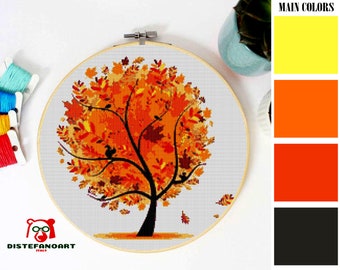 May include: A cross-stitch pattern featuring a stylized tree with orange, yellow, and brown leaves. The pattern is displayed in a round embroidery hoop.