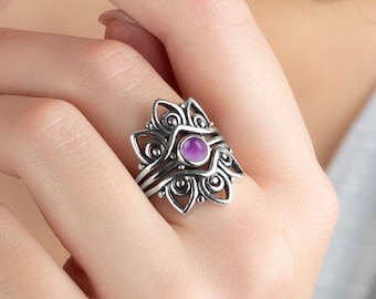 May include: A silver ring with a purple amethyst gemstone set in a floral design.