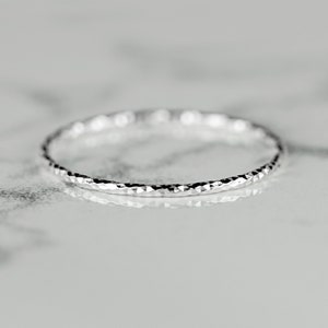Puede incluir: Un fino anillo de plata con textura martillada.