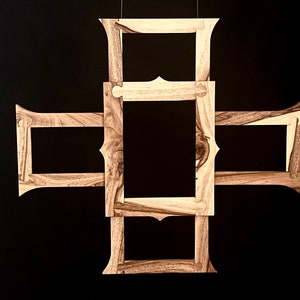 May include: A wooden picture frame with a unique design, featuring four separate frames that are connected to form a cross shape.
