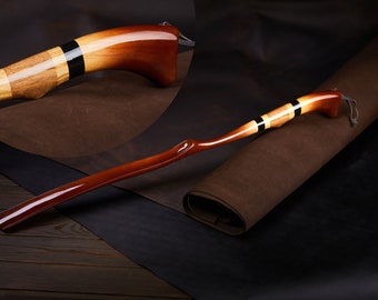 May include: A wooden shoehorn with a curved handle and a black and yellow striped design. The shoehorn is made of polished wood and has a smooth finish.