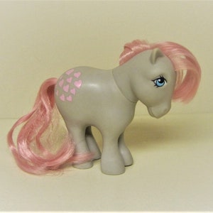 May include: A gray My Little Pony toy with pink hair and a heart pattern on its flank.