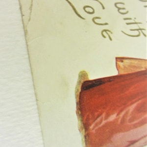 Puede incluir: Una postal vintage con una ilustraci&oacute;n roja y blanca de una mujer con un vestido. El texto "with love" est&aacute; escrito en letras doradas en la postal.