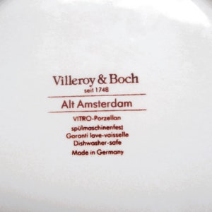 May include: Close-up of the bottom of a white ceramic plate with brown text that reads "Villeroy & Boch seit 1748 Alt Amsterdam VITRO-Porzellan sp&uuml;lmaschinenfest Garanti lave-vaisselle Dishwasher-safe Made in Germany".