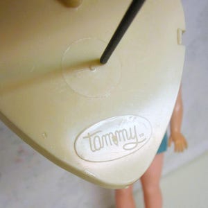 May include: A white plastic doll stand with a black metal rod and a "Tammy" logo.