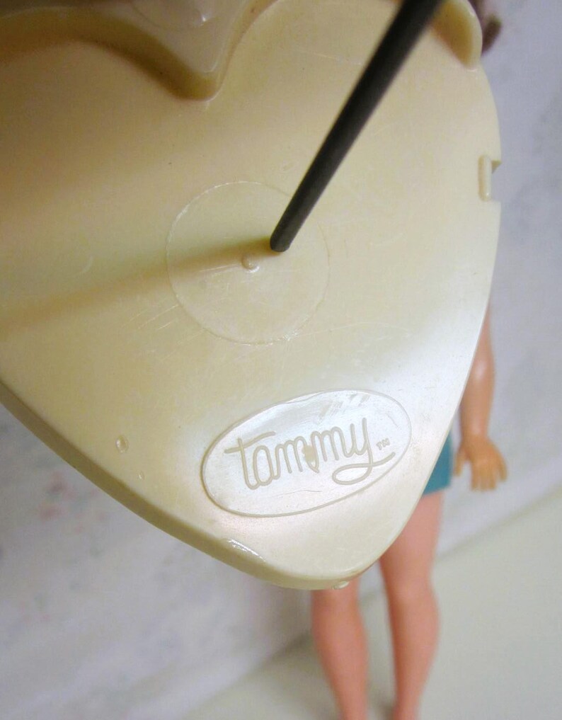 May include: A white plastic doll stand with a black metal rod and a "Tammy" logo.