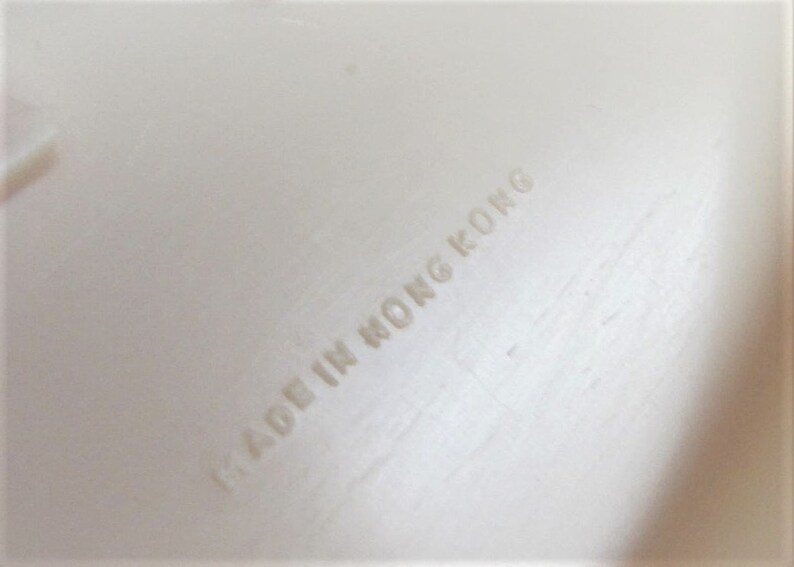 Puede incluir: Etiqueta blanca con el texto "MADE IN HONG KONG" impreso en ella.