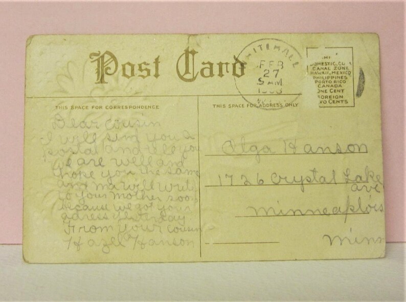 Puede incluir: Una postal vintage con un mensaje escrito a mano. El mensaje dice "Querida prima Te enviar&eacute; una postal y te dir&eacute; que estamos bien y espero que t&uacute; tambi&eacute;n est&eacute;s bien y mam&aacute; escribir&aacute; a tu madre pronto porque tenemos tu direcci&oacute;n desde el otro d&iacute;a De tu prima Tof azel fanson". La postal est&aacute; dirigida a "Alga 14 anson 1726 Crystal Lake Minneapolis Minn".