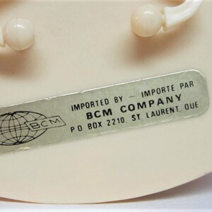 Puede incluir: Una pegatina plateada con un globo terr&aacute;queo y el texto "BCM" en ella. La pegatina est&aacute; pegada a un objeto de pl&aacute;stico blanco. El texto "IMPORTED BY - IMPORTE PAR BCM COMPANY PO BOX 2210 ST LAURENT, QUE" est&aacute; impreso en una pegatina plateada.