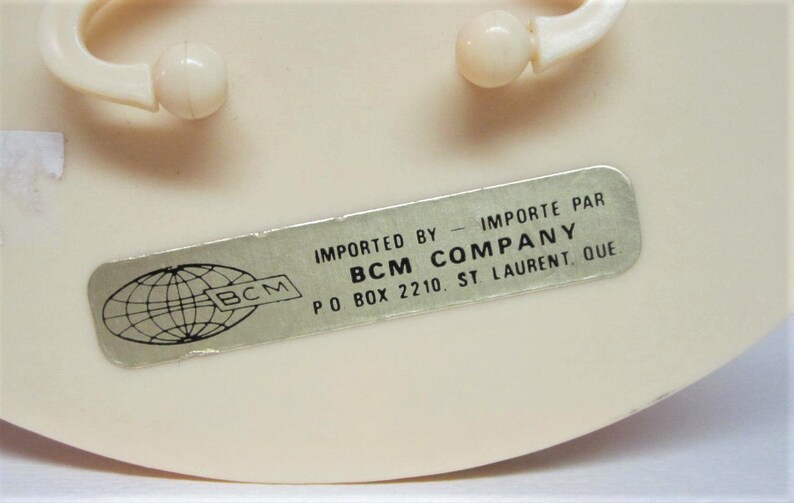 Puede incluir: Una pegatina plateada con un globo terr&aacute;queo y el texto "BCM" en ella. La pegatina est&aacute; pegada a un objeto de pl&aacute;stico blanco. El texto "IMPORTED BY - IMPORTE PAR BCM COMPANY PO BOX 2210 ST LAURENT, QUE" est&aacute; impreso en una pegatina plateada.