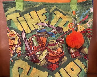 Bolsa artesanal inspirada nas Tartarugas Ninja - Bolsa acolchoada de 45 cm com estampa dos personagens - Chaveiro com pompom - Interior forrado - Bolso - Bolsa de viagem infantil