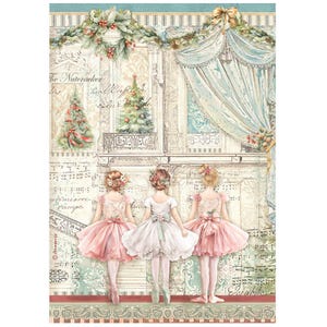May include: Three young ballerinas in pink tutus stand on a stage with a backdrop of a Christmas scene. The stage is decorated with a garland of greenery and a Christmas tree. The text "The Nutcracker" is visible in the background.