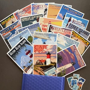 May include: A collection of lighthouse-themed postcards featuring various locations like Cape Cod, Hilton Head Island, and Key West. The postcards have vintage travel poster designs with vibrant colors and lighthouse illustrations. A blue envelope and stamps are also visible.