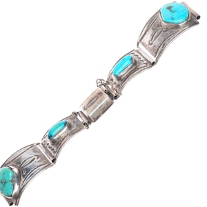 May include: A silver link bracelet featuring four polished turquoise stones set in curved metal plates. Each silver segment is decorated with etched patterns and connected by small metal hinges, creating a flexible structure for the wrist.