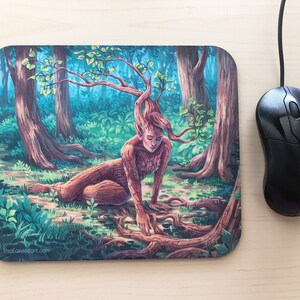 Könnte beinhalten: Eine Mauspad mit einer farbenfrohen Illustration einer Baumnymphe in einer Waldlandschaft. Die Nymphe hat einen Baumstamm als Körper und Äste als Haare. Der Hintergrund ist ein üppiger grüner Wald mit hohen Bäumen.