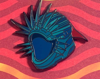 May include: A blue and red enamel pin featuring a detailed, stylized helmet with spikes. The helmet has a blue visor and is set against a red and orange wavy background.