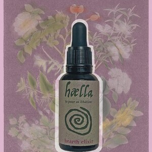 Op de afbeelding: Een donkere glazen fles met een druppelaar, met het label "hælla" en "hearth elixir". Het label heeft een spiraalontwerp en de woorden "to pour as libation". De achtergrond is een bloemenontwerp op een roze achtergrond.