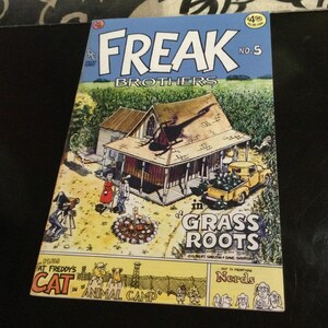 May include: Comic book cover for Freak Brothers No. 5, featuring a rural scene with a house, truck, and characters. The title "FREAK BROTHERS" is in large letters above the illustration. The comic also features "Fat Freddy's Cat in Animal Camp".