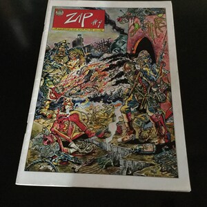 May include: Comic book cover for "ZAP #9" featuring a colorful, detailed illustration. The artwork depicts a chaotic scene with figures in military attire, explosions, and fantastical creatures. The title "ZAP" is in a red box.